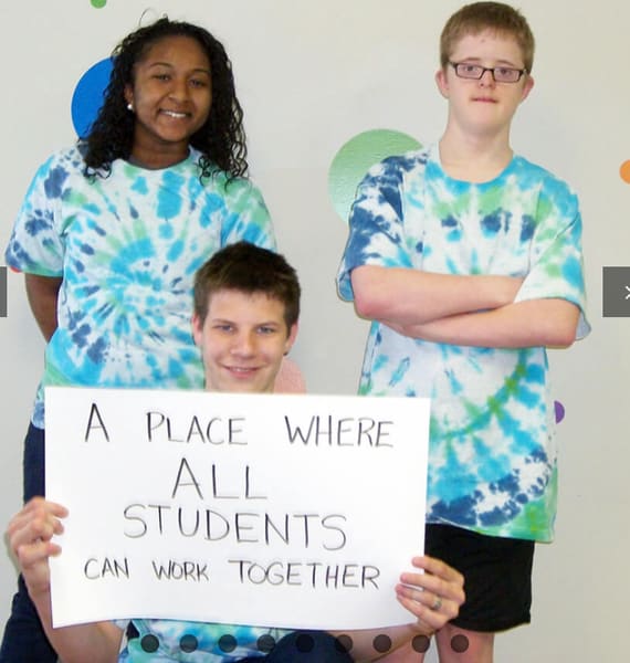 Henderson Haven students holding a sign reading ‘A place where all students can work together’